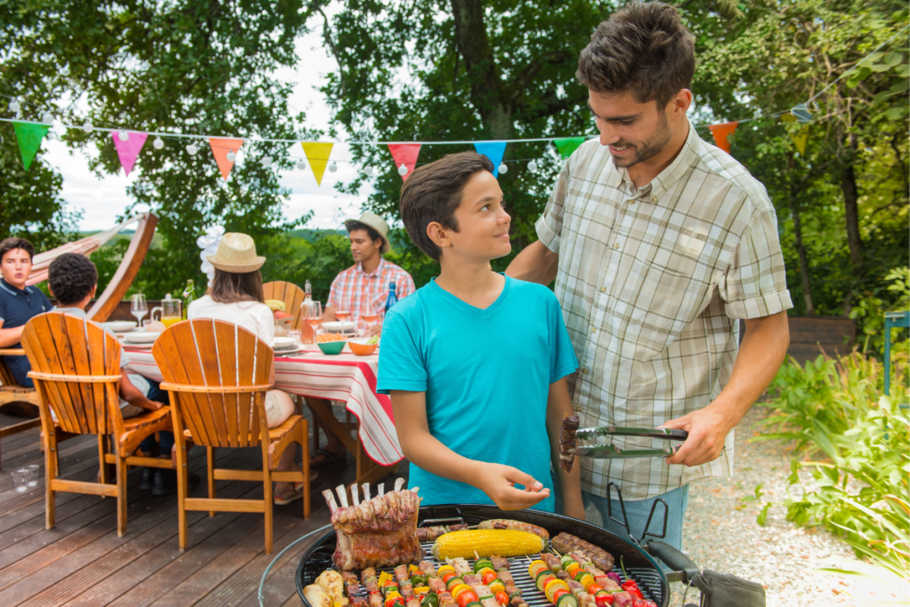 Dad and son manning the grill at an outdoor bbq gathering