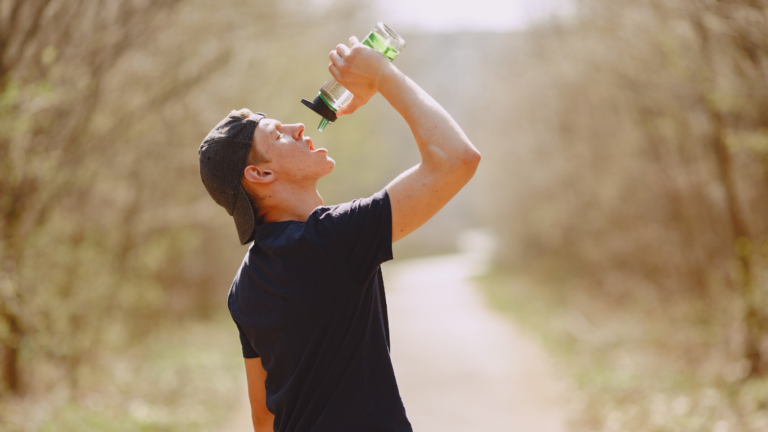 Man drinking water from a bottle in nature